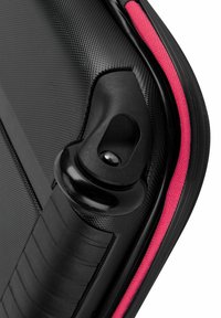 Valigia rigida nera con angolo arrotondato e alloggiamento delle ruote in plastica nera. Presenta un accento in tessuto rosa lungo la cerniera e una superficie testurizzata.