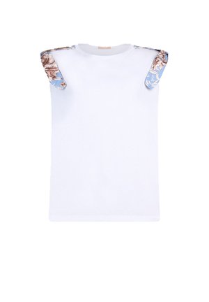 Maglietta bianca senza maniche con dettagli sulle spalle in tessuto blu e motivi floreali marroni.