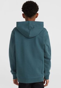 Felpa teal con tasca a marsupio, cappuccio regolabile e polsini a coste. Texture morbida e vestibilità comoda, adatta per un abbigliamento informale.