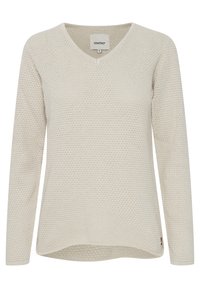 Pull beige en maille avec col en V, manches longues et motif texturé. Ourlet arrondi avec une légère queue de pie, orné d'une petite étiquette de marque.