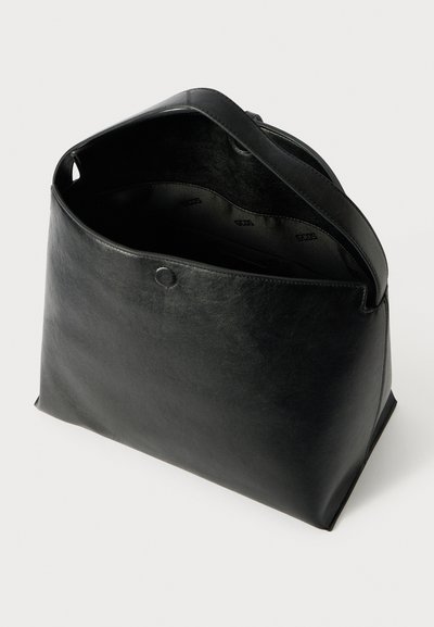 Borsa tote in pelle nera con forma strutturata, apertura superiore e chiusura a bottone a pressione. Texture morbida e design minimalista con branding interno.