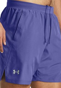 Lila idrottsshorts i lätt material. Har ett elastiskt midjeband med dragsnöre, sidfickor och meshdetaljer.