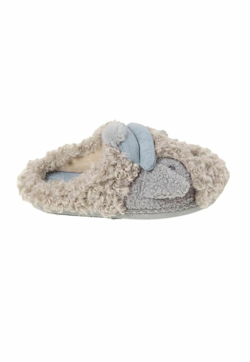 Fuzzy beige slipper with a rounded shape, featuring a blue accent panel and a soft pom-pom detail, designed for comfort and warmth.
