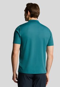 Teal polo shirt with a classic collar, short sleeves, and a smooth texture. Features a straight hem and subtle seam detailing.