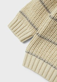 Maglione lavorato a maglia in bianco sporco con accenti a strisce grigie, caratterizzato da polsini a coste e un tessuto testurizzato per calore e comfort.