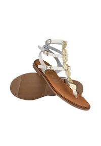 Sandalias blancas de tiras con acentos de monedas doradas, suela plana marrón, correas ajustables y detalle de plantilla texturizada.