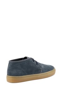 Stivali ankle in suede blu scuro, con punta arrotondata, lacci blu navy e suola in gomma beige, caratterizzati da una texture liscia e cuciture minime.