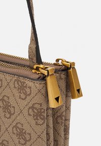 Brązowa torebka wzorzysta o usztywnionym kształcie, wyposażona w zamek błyskawiczny i złote elementy metalowe. Materiał ma fakturowane wykończenie.