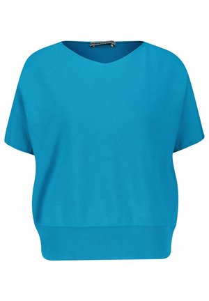 Haut turquoise à manches courtes avec un col en V, ourlet côtelé et texture douce. Coupe ample, design décontracté, adapté à la superposition ou à porter seul.