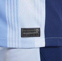 Hellblaue und marinefarbene Sportstoff mit vertikalen Streifen, versehen mit einem schwarzen Etikett, auf dem "ENGINEERED" und ein Zahlencode steht.