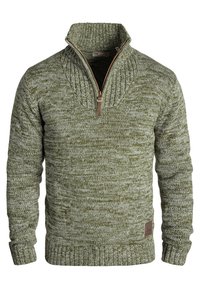 Suéter de punto verde con cuello alto y medio cierre. Patrón texturizado y puños y dobladillo de canalé. Parche de cuero con logo en el lateral.