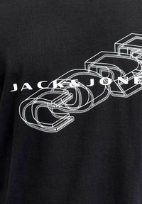 Must must t-särk mustas värvitoonis, millel on suur valge graafiline tekst, mis on 3D efektiga ja millel on julge, stiliseeritud kiri "JACK & JONES".