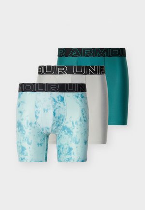 Tre boxer briefs med sorte linninger med teksten "UNDER ARMOUR"; farverne inkluderer blå tie-dye, lysegrå og solid teal.