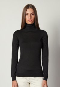 Schwarzer Rollkragenpullover aus einem glatten, leichten Stoff. Verfügt über lange Ärmel und ein enganliegendes Design mit einem gerippten Saum.