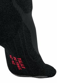 Calza tecnica nera con modelli testurizzati, sezioni elastiche e logo rosso "FALKE RU TRAIL". Punta e tallone rinforzati per una maggiore durata.