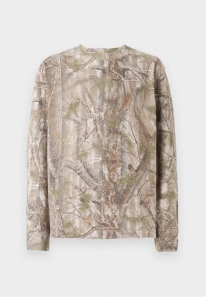 Langermet skjorte i camouflage-mønster med nyanser av brunt, grønt og grått, rund hals og avslappet passform. Den teksturerte overflaten minner om trærnes bark.