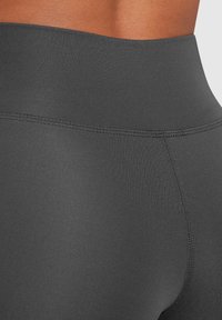 Leggings neri a vita alta realizzati in tessuto liscio e elasticizzato. Presentano cuciture piatte per una maggiore comodità e una silhouette aderente e slanciata.