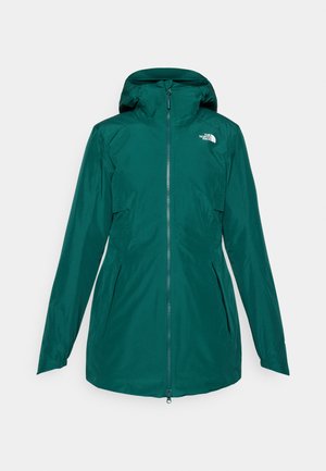 Veste imperméable teal avec fermeture éclair à l'avant et capuche ajustable. Présente des poches latérales et un logo sur le haut gauche de la poitrine.