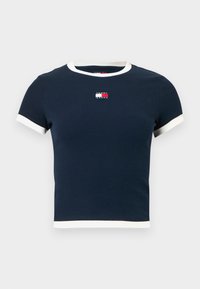 Tmavomodré rebrované bavlnené tričko s krémovo sfarbeným golierom a lemami rukávov. Na hrudi je malá logo. Strihaný dizajn.