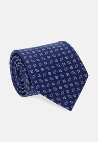 Corbata azul marino hecha de un tejido texturizado, con un patrón geométrico repetido en azul claro y blanco. Diseño enrollado para un fácil almacenamiento.