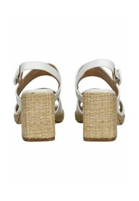 Sandali bianchi con tacco a blocco in paglia intrecciata, cinturini alla caviglia e dettagli con fibbia. Texture liscia con un design minimalista.