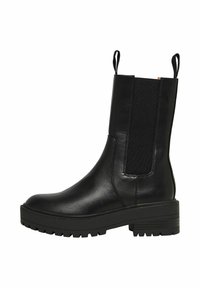 Bottine en cuir noir avec des panneaux latéraux élastiques, bout rond et semelle épaisse. Dispose de tirettes pour un enfilage facile, finition texturée sur la tige.