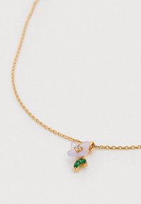 Zelta ķēdes kaklarota ar lavandas ziedu piekariņu, rotātu ar caurspīdīgu dārgakmeni centrā un diviem zaļiem lapu akcentiem.