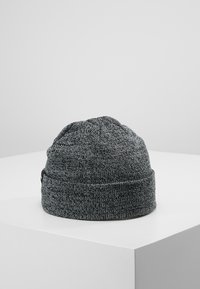 Knitted gray beanie hat with a textured finish, featuring a rolled cuff and rounded top. Made of soft, stretchy fabric.