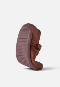 Zapato marrón de cuero tipo slip-on con un acabado texturizado y suela de goma que presenta ranuras horizontales; correa ajustable para el cierre. Talla 26.