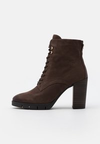 Brauner Lederknöchelboot mit hohem Blockabsatz, Schnürung vorne und goldenen Ösenakzenten. Glatte Textur mit rundem Zehenbereich und Gummisohle.