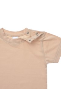 Beige T-Shirt mit kurzen Ärmeln aus weichem Stoff, mit Druckknopfverschluss an der Schulter. Glatte Textur, einfaches Design und ohne Muster.