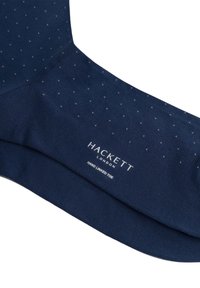 Calzino in misto cotone blu navy con un motivo testurizzato di piccoli punti. Presenta il nome del marchio "Hackett London" e "Punta Cucita a Mano" stampati in bianco.