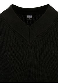 Suéter negro de punto con diseño de cuello en V, que presenta un tejido texturizado. El interior muestra un patrón de forro fino. Etiqueta visible en el cuello.
