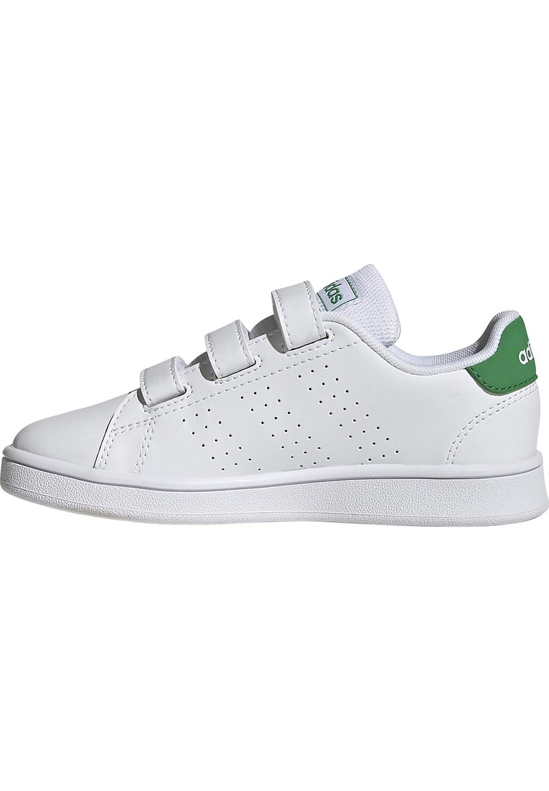 Zapatilla de cuero blanco con detalles perforados, correas de velcro y un acento verde en el talón. Incluye una suela de goma blanca texturizada.