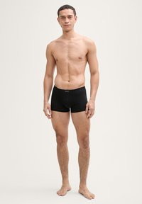 Zwarte boxershorts van zachte stof, met een middelhoge tailleband en een strakke pasvorm, met minimale stiksels en zonder zichtbare logo's.
