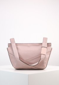 Borsa a tote in pelle rosa con superficie texturizzata, caratterizzata da un design angolare, manici superiori e un dettaglio in metallo a forma di fibbia.