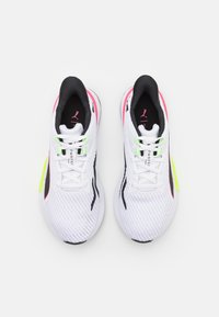 Zapatillas deportivas blancas con parte superior de malla, detalles en negro, talón de color rosa brillante y puntas de cordones en verde neón. Cordones planos y cuello acolchado.