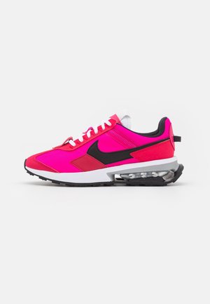 Jasnoróżowo-czerwony sneaker Nike z czarnym logo, białymi sznurówkami, widoczną amortyzacją powietrzną w podeszwie i czarną podeszwą antypoślizgową.