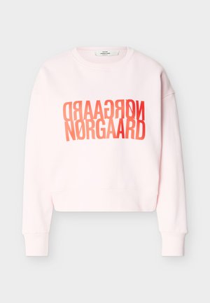 Sweat-shirt rose clair à col rond avec manches longues et design de texte "NØRGAARD" rouge miroir centré sur le devant.