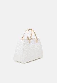 Biała pikowana torebka o zwartym kształcie, z elementami w kolorze złotym i podwójnymi rączkami. Posiada geometryczne wzory przeszyć.