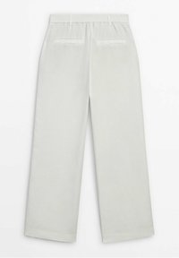 Pantalon beige clair à jambes larges avec taille élastique, doté de deux poches arrière et d'une texture lisse légèrement brillante.