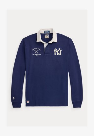Tengerészkék, hosszú ujjú rögbimez fehér gallérral, New York Yankees logóval, keresztbe tett ütőkkel és Polo Ralph Lauren márkajelzéssel.