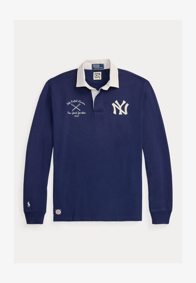 Tengerészkék, hosszú ujjú rögbimez fehér gallérral, New York Yankees logóval, keresztbe tett ütőkkel és Polo Ralph Lauren márkajelzéssel.