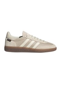 Baskets Adidas beige avec trois bandes blanches, semelle en gomme, dessus en mesh et daim, et étiquette Contour près du talon.
