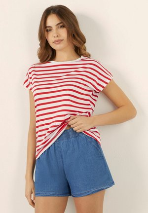 T-shirt rayé rouge et blanc à manches courtes, associé à un short en denim avec une taille élastique et une coupe décontractée.
