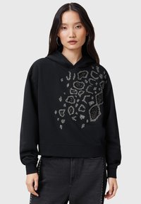 Hoodie nero corto realizzato in tessuto morbido, caratterizzato da un motivo leopardato argentato a trama sulla parte anteriore. Cappuccio con cordino regolabile, maniche lunghe.