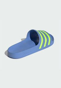 Adidas papuče s plavim sintetičkim gornjim dijelom, zakrivljenog oblika, otvorenim dizajnom prstiju, s tri svijetle žute pruge preko vrha.