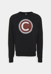 Sudadera negra con un logo redondo que presenta una "C" en color granate en el centro, acentos grises y puños y dobladillo acanalados. Textura suave, estilo pullover.