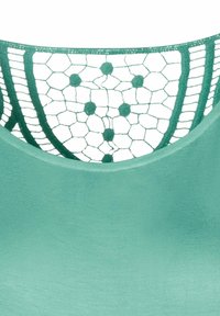Zelený top s hladkým materiálom a čipkovým chrbtom, ktorý má hexagonálny vzor a detaily v puntíkoch.