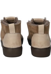 Beige ankle boots with a textured leather exterior and soft fur lining. Features a brown rubber sole and rear pull tab for easy wear.